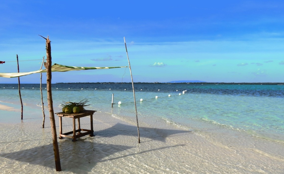 Strandabschnitt mit einem Tisch im Wasser und einem Sonnenschutz dar&uuml;ber auf der Insel Bohol