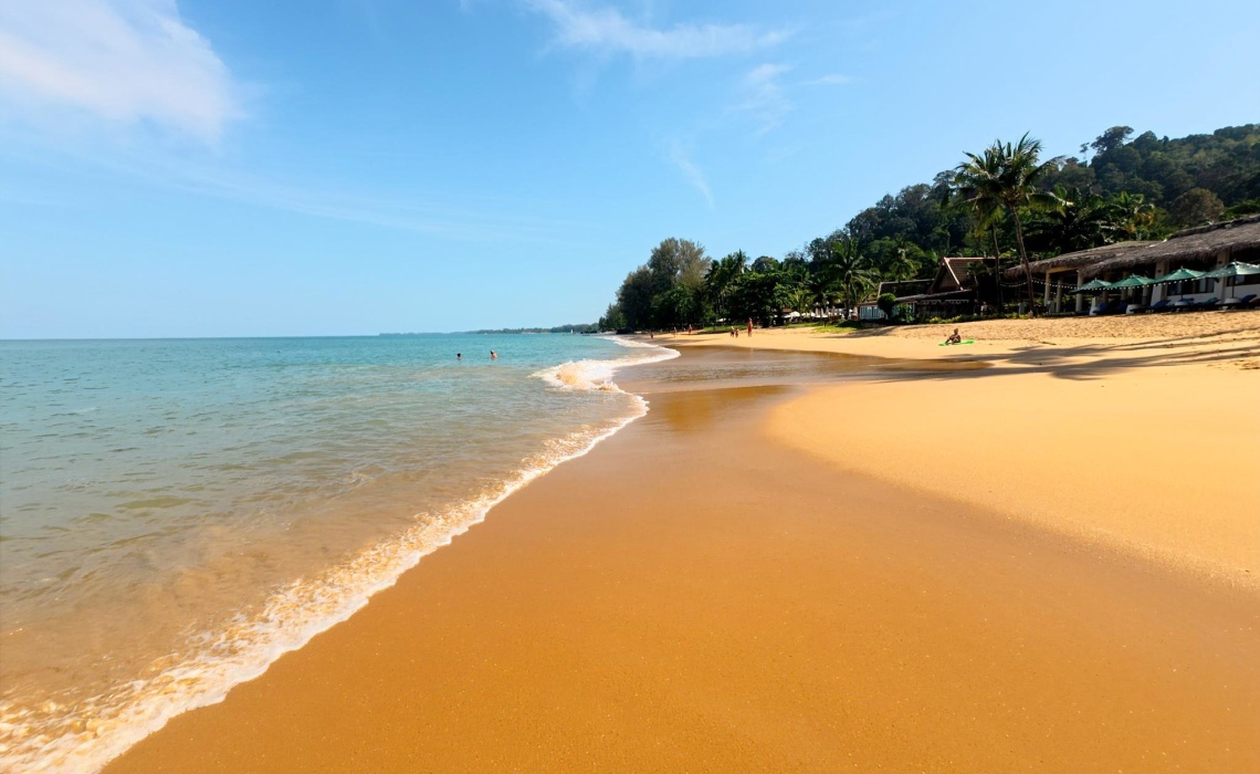Einsamer Strand Thailand, Sand, Meer und Bewaldung im Hintergrund
