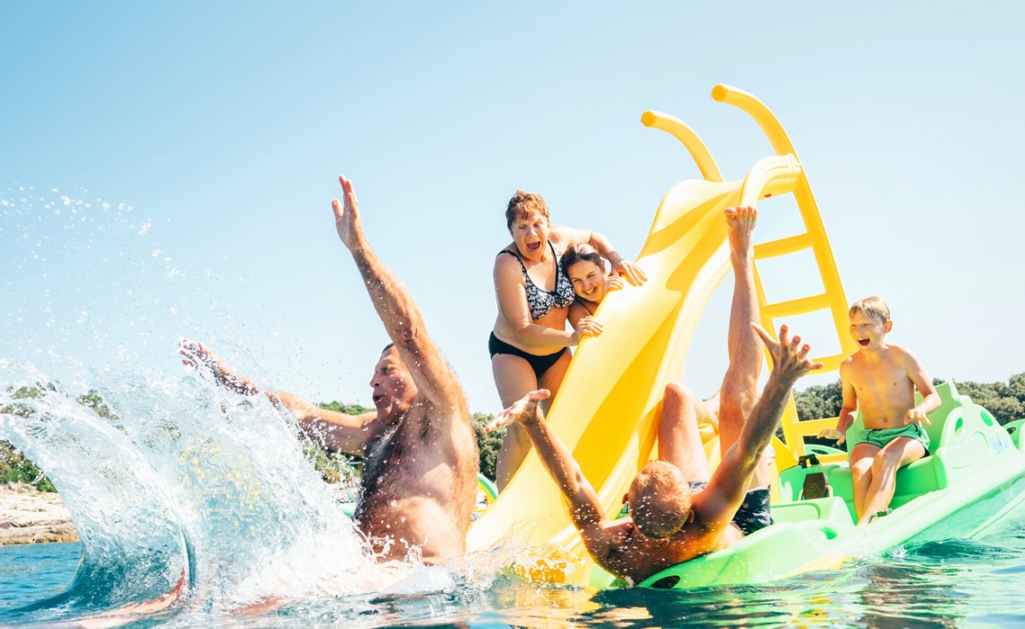 Familie mit Kindern im Wasser auf einer Rutsche die Spa&szlig; haben