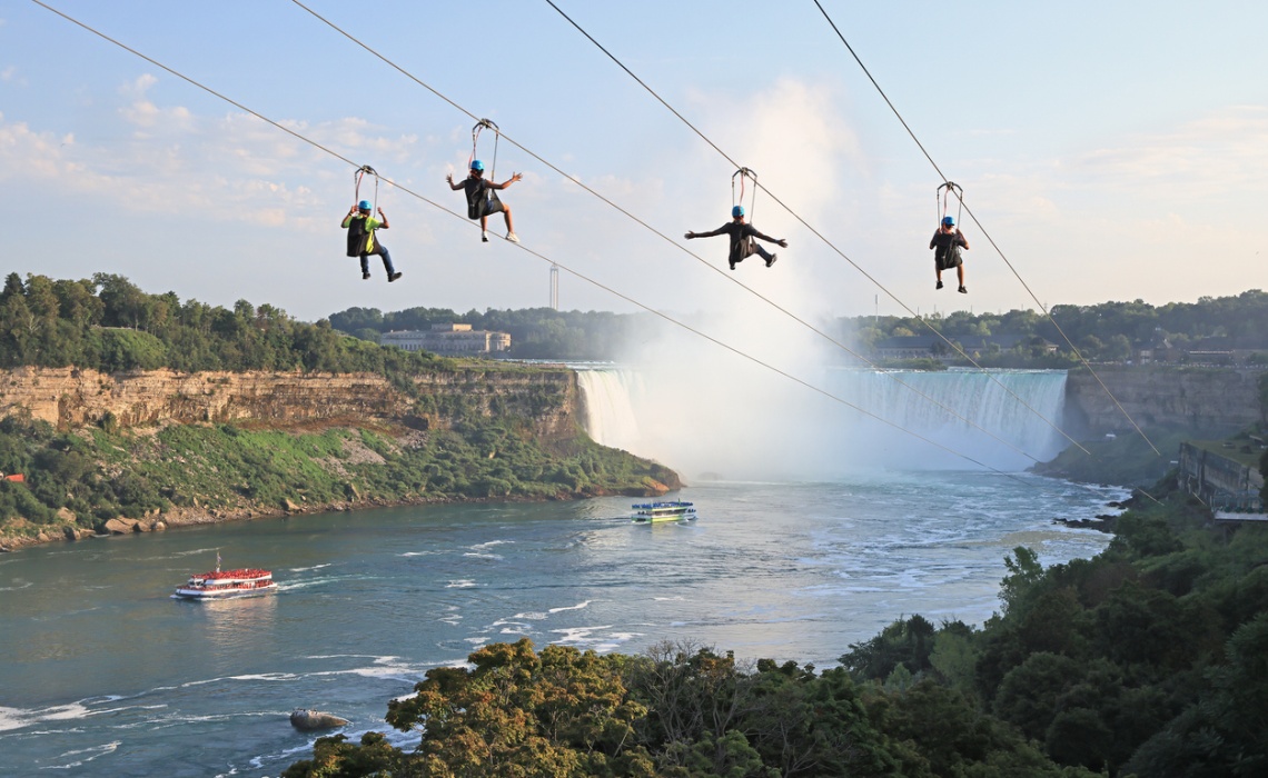 4 Menschen auf einer Zipline, Hintergrund Wasserfall
