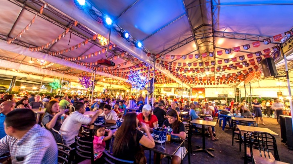 Menschen im Freien sitzend in Manila, die Essen und Trinken