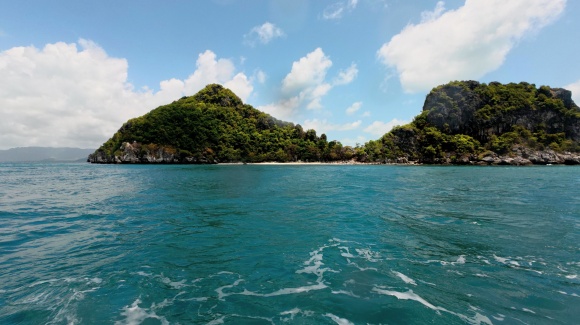 Blick vom Meer auf eine kleine gr&uuml;ne Erhebung der Five Islands