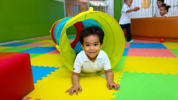 Kind beim Spielen auf dem Boden liegend